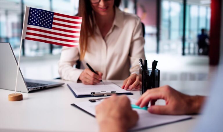 an immigration lawyer taking notes and filling documents while discussing the process with a client