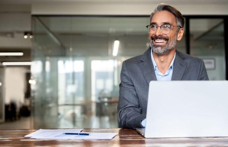 Happy middle-aged businessman working on the laptop