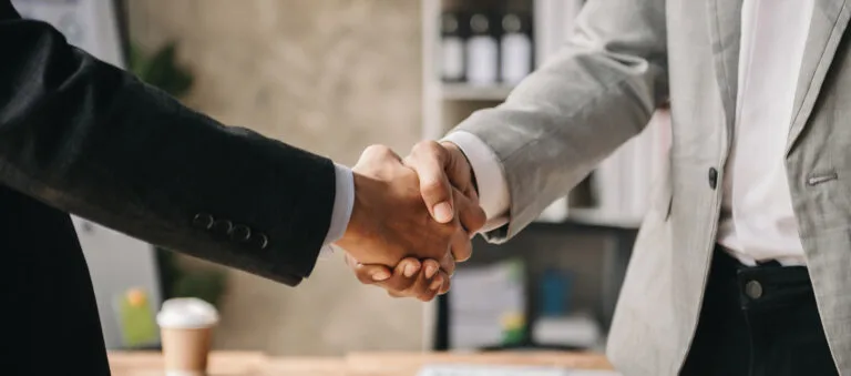 Two confident business man shaking hands during a meeting in the office, success, dealing, greeting and partner